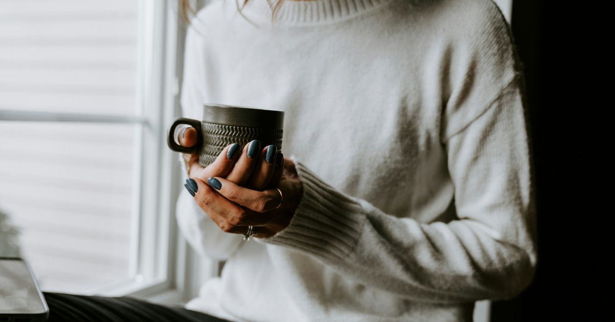 Woman-by-a-window-holding-coffee-cup.jpg